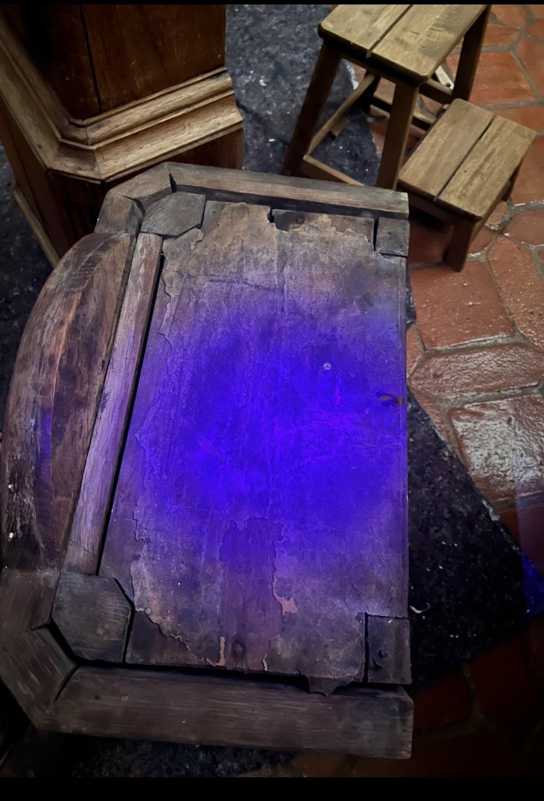 The hood's roof entirely under ultraviolet light, showing organic residue and the boundaries of the cracks