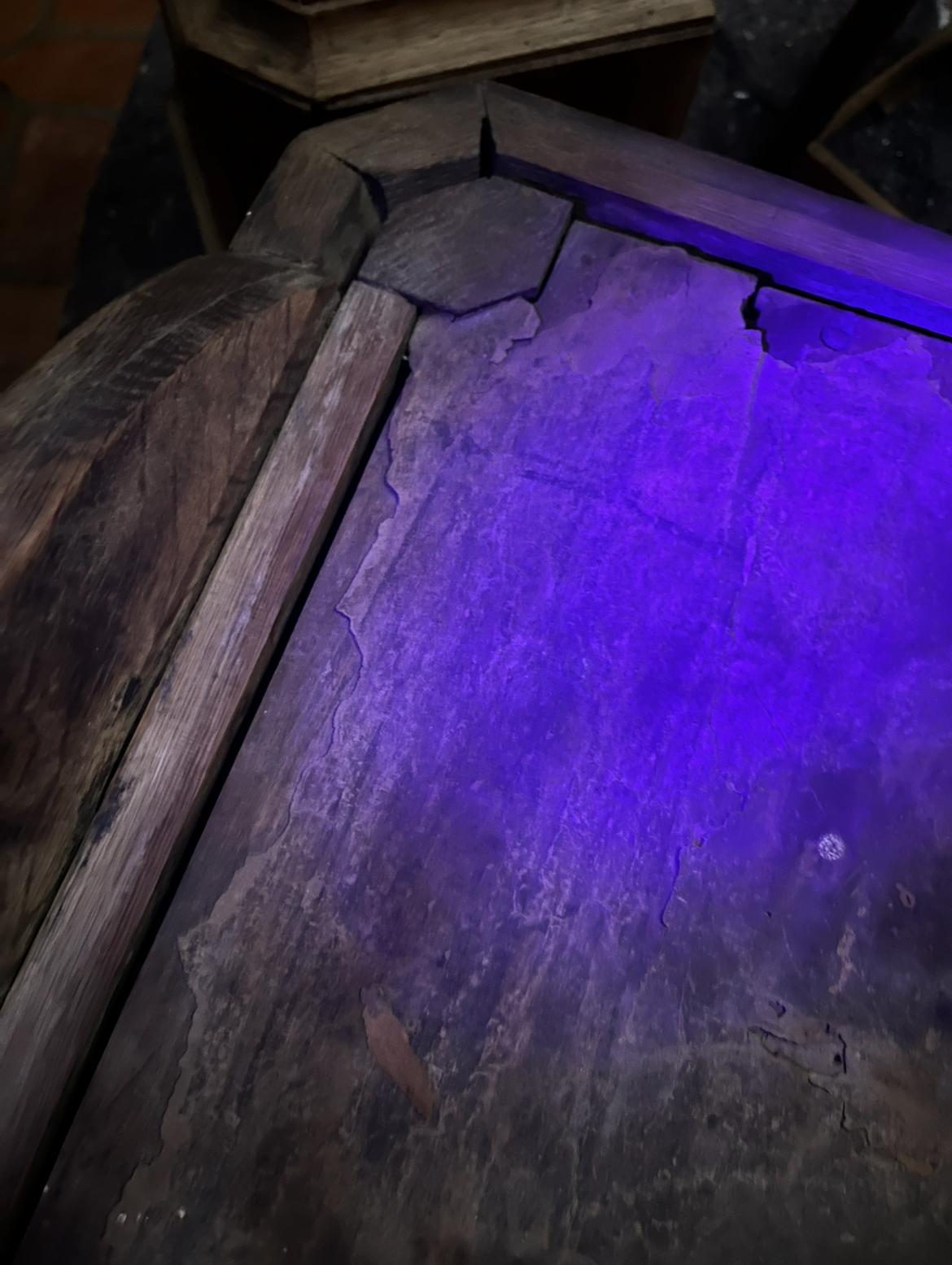 A corner of the roof under ultraviolet light near the carved joint, with a clear pattern of cracks