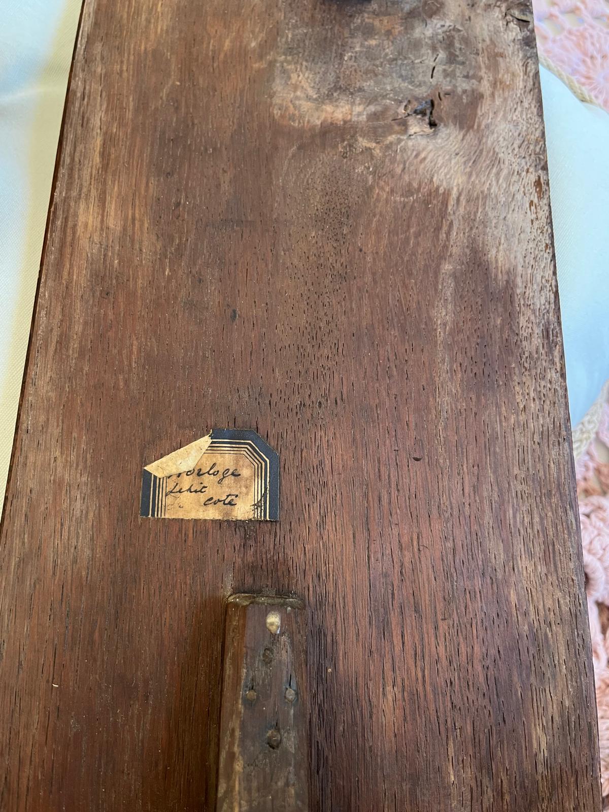 An antique blue label on the shutter board, handwritten with Horloge petit côté
