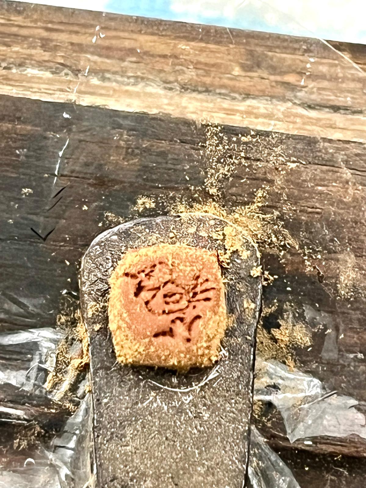 The wet cold-weld collar, dusted with walnut powder, with the bird mark pressed in