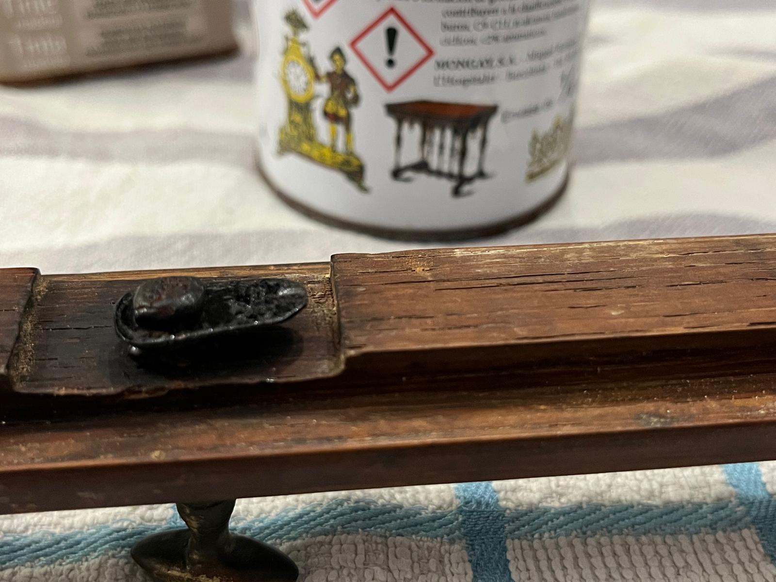 A final view of the latch on the frame, next to the tin of bitumen