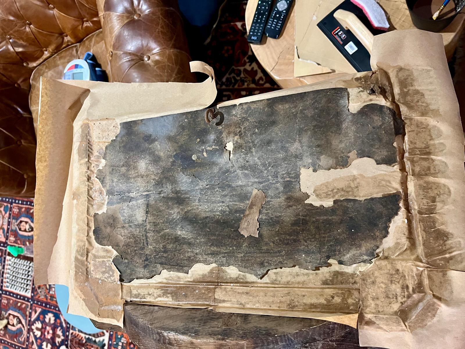 Kraft paper being fed under the raised edges of the parchment, the forged hook visible at center