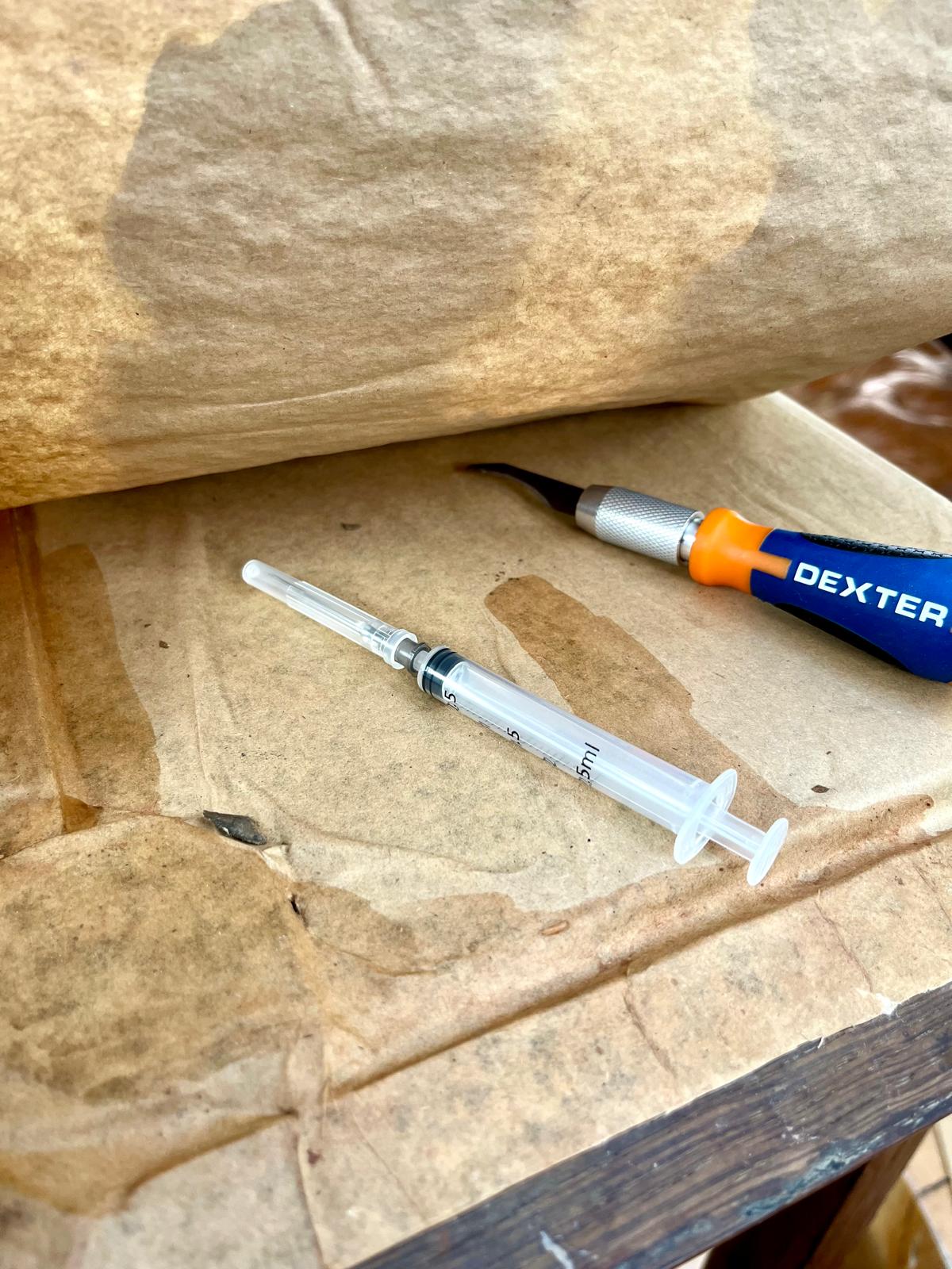 The curved Dexter Steel chisel and the 2 ml syringe — the operation's main tools