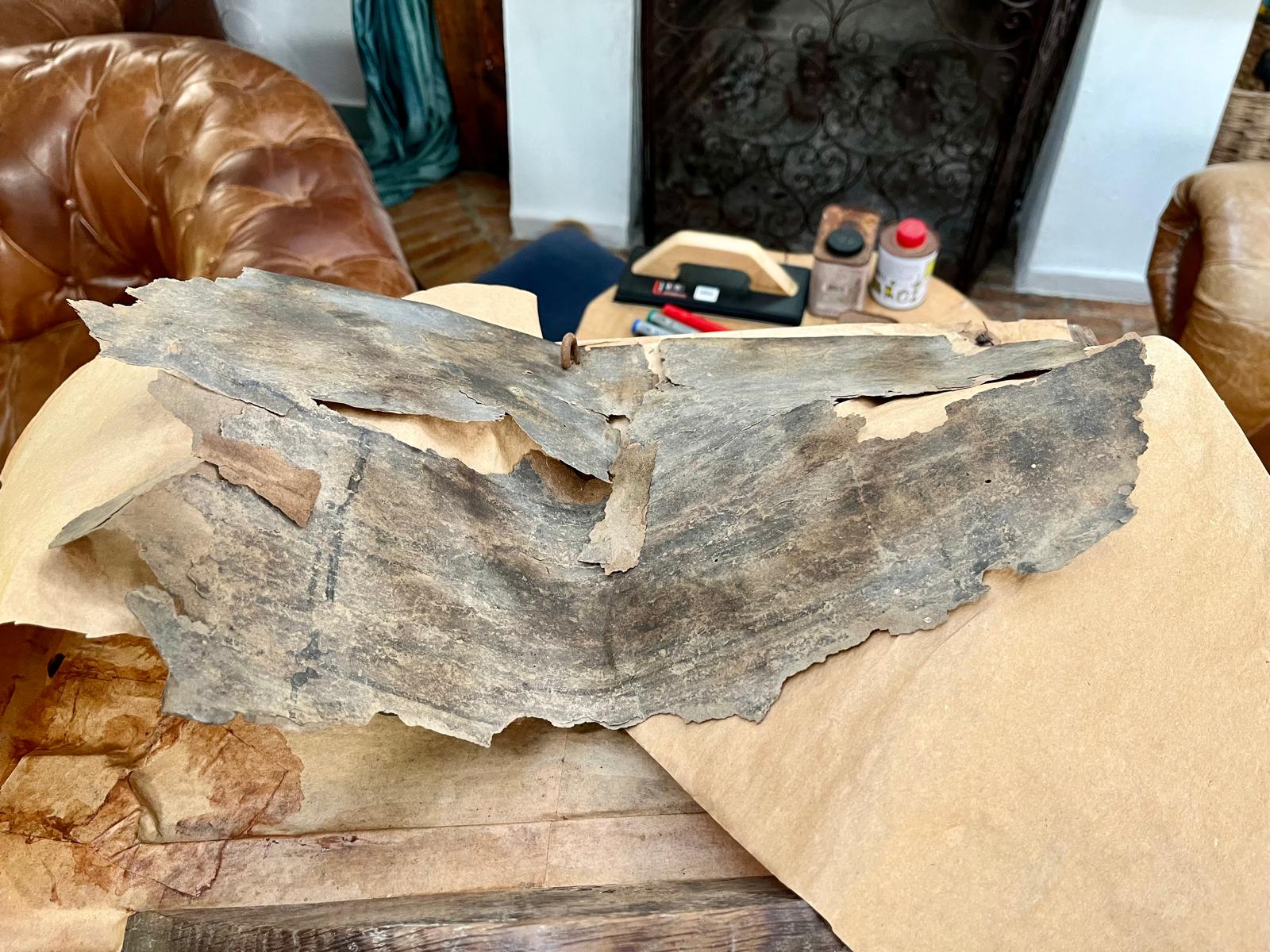 The parchment laid over the full sheet of kraft paper, the forged hook still in place