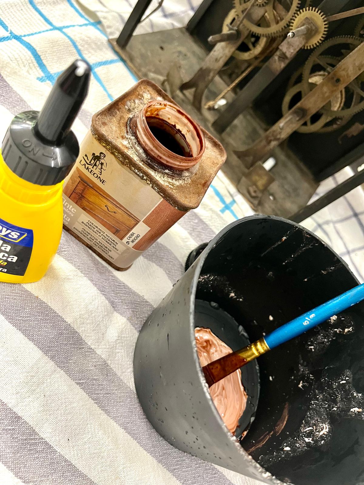 The mixing begins: PVA and the Caoba tint being worked with a brush, next to the clock's movement