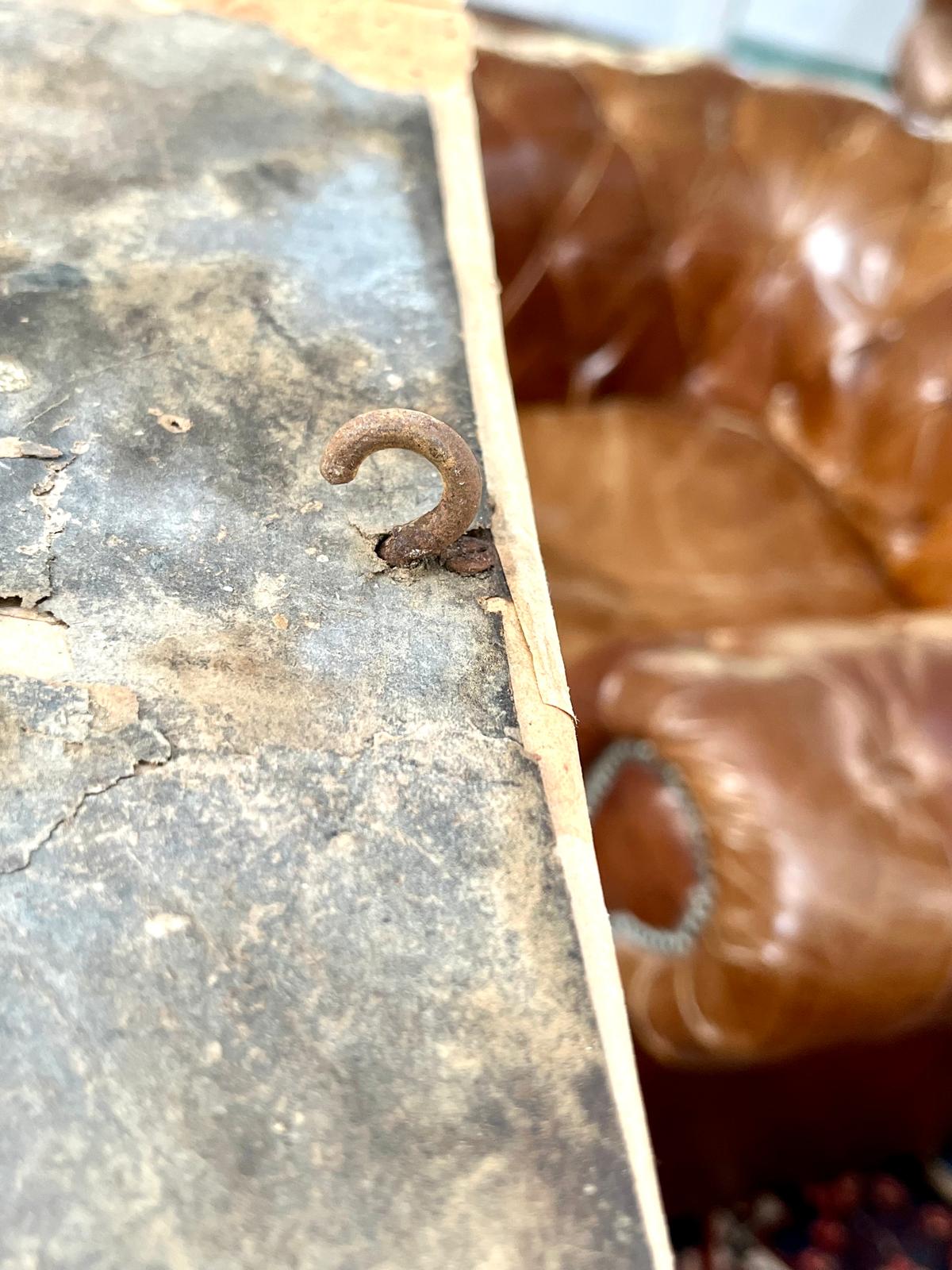 Close-up of the forged metal anchor hook at the edge of the roof shell