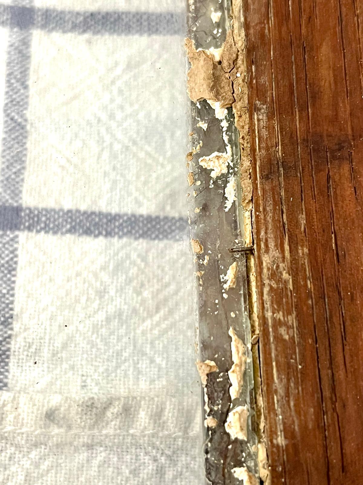 A forged pin holding the glass in place, in the frame's rebate