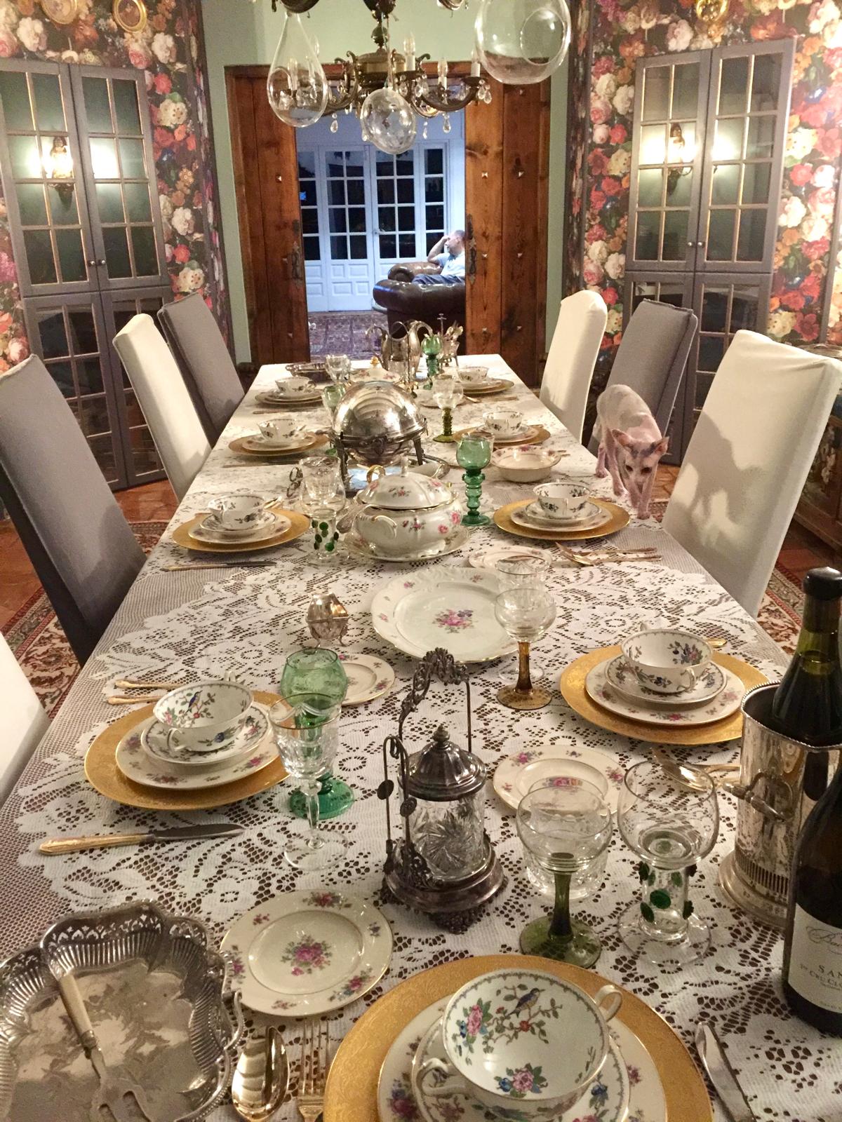 Bibisechka parading across the dining table between the vintage porcelain and crystal
