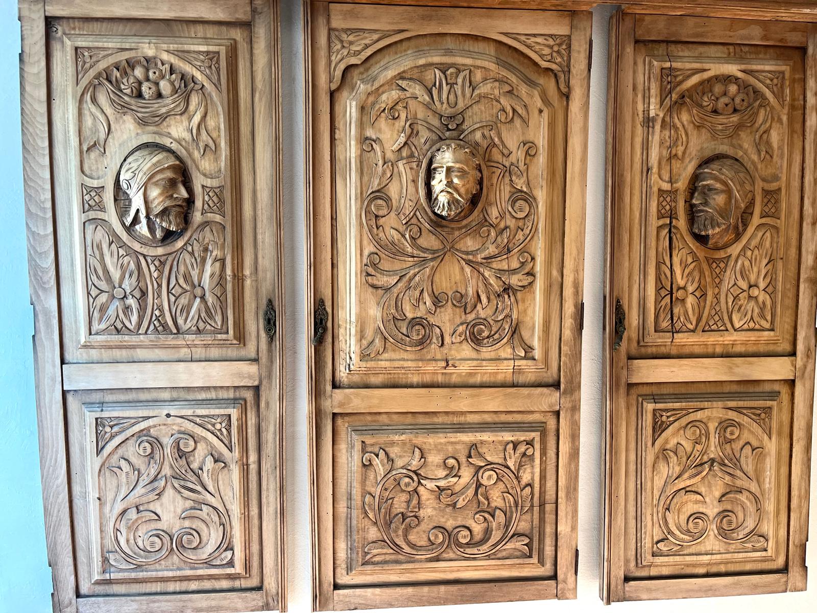 An overall panorama of the three carved oak panels on the wall after the ammonia cleaning