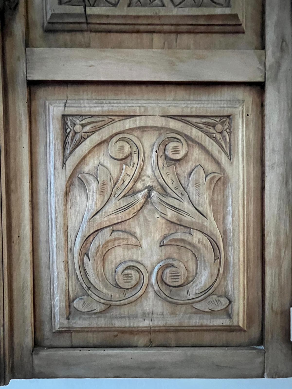 Close-up of the lower ornamental scroll panel with symmetrical acanthus volutes