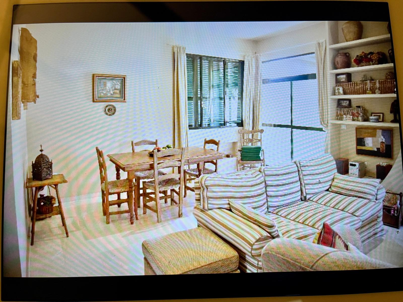 The living room with its fireplace and soft striped sofas