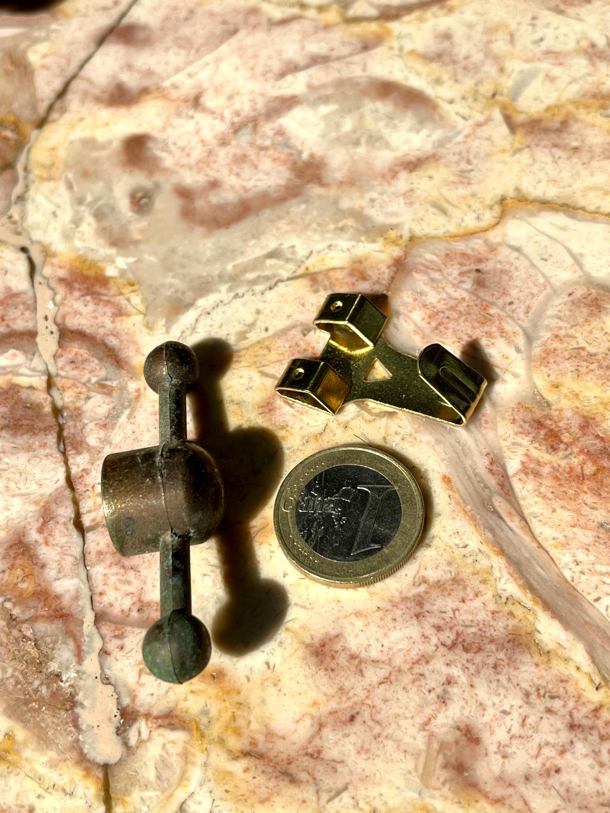 Modern hardware tried on for scale and geometry, next to a coin