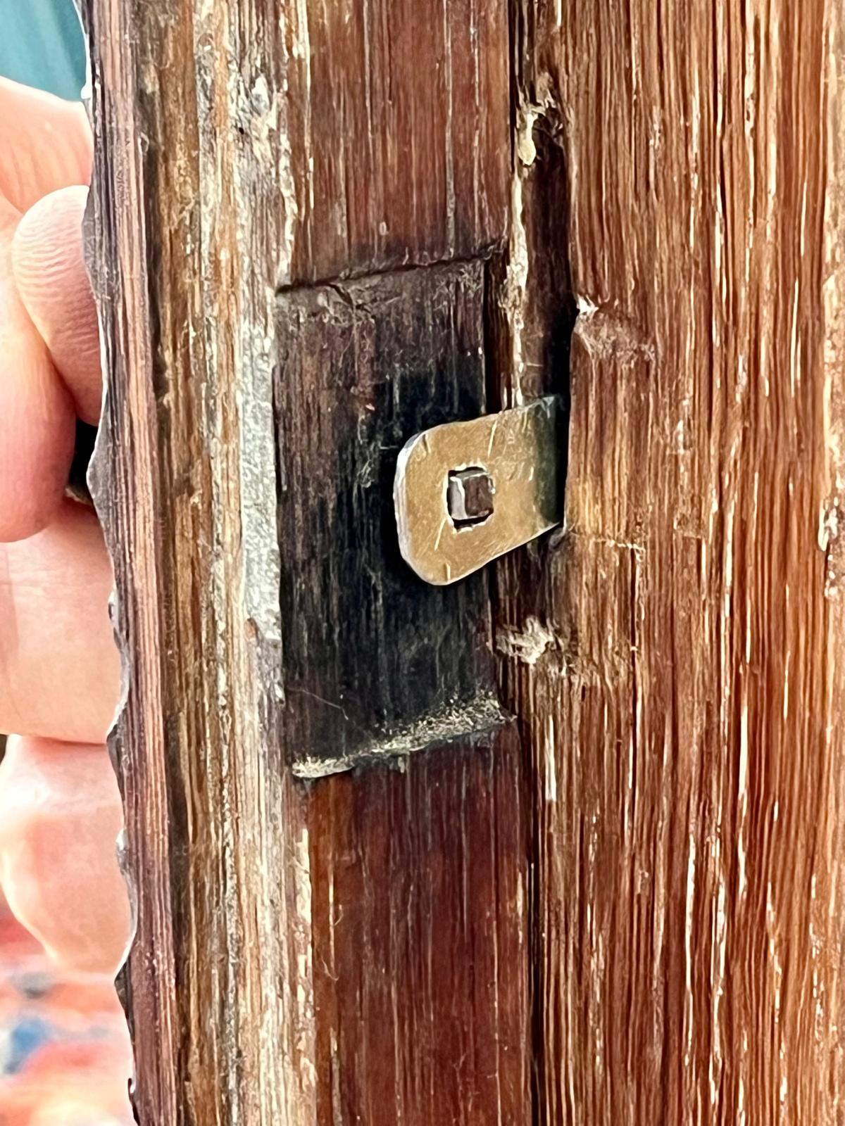 The steel blank with its rounded-square bore and teardrop tab, test-fitted into the slot