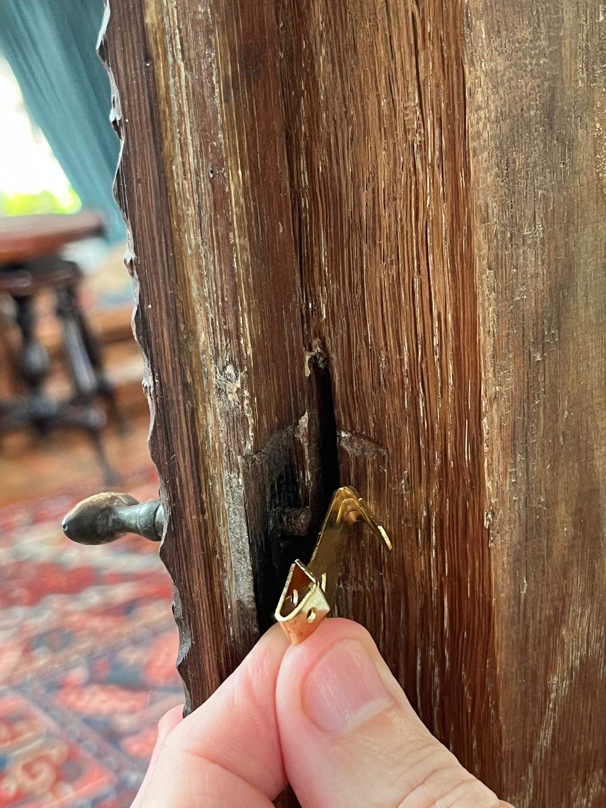 Test-fitting an alternative brass fitting in the door's slot