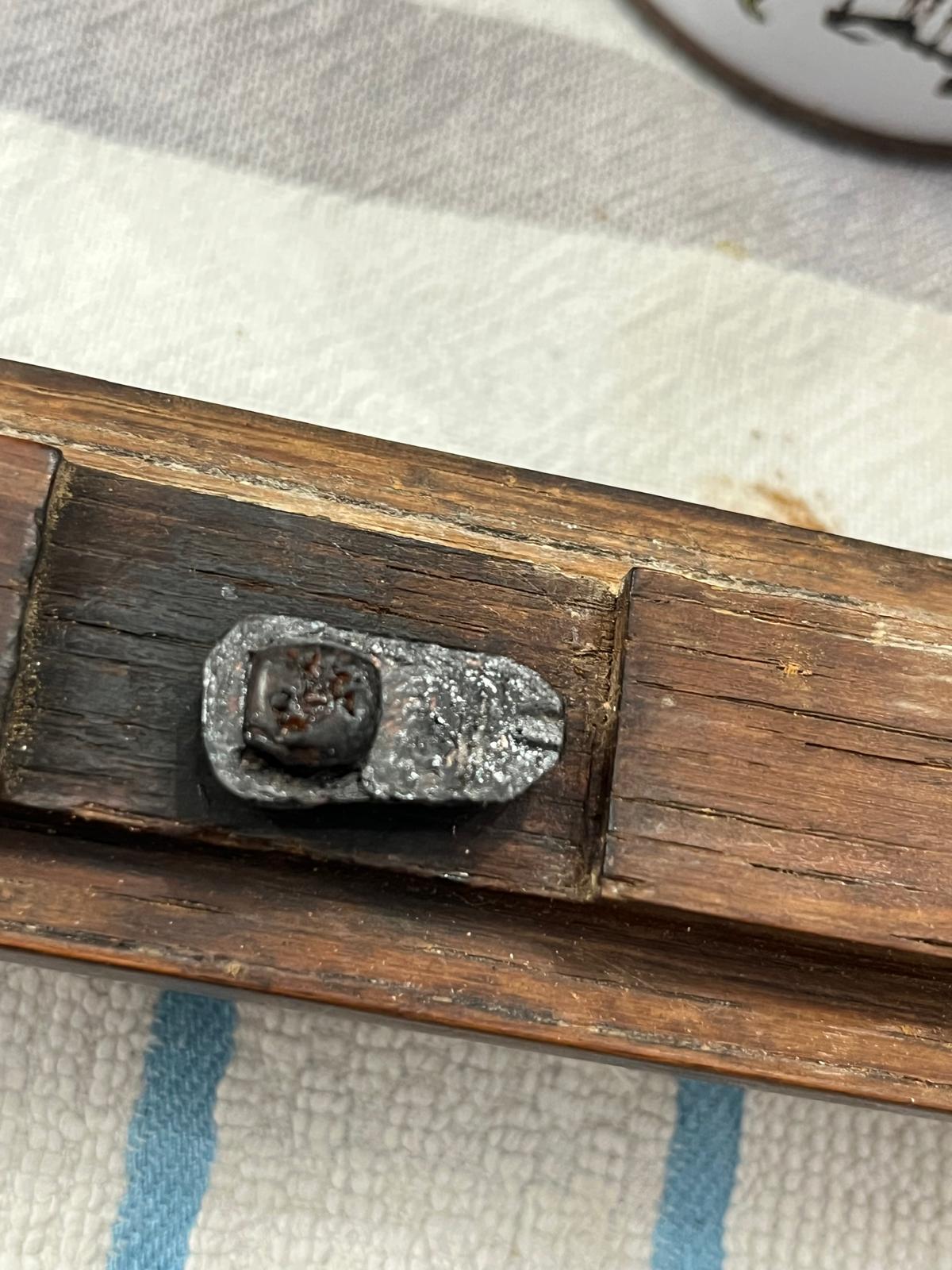 The finished, newly made latch, darkened with bitumen and mounted in place
